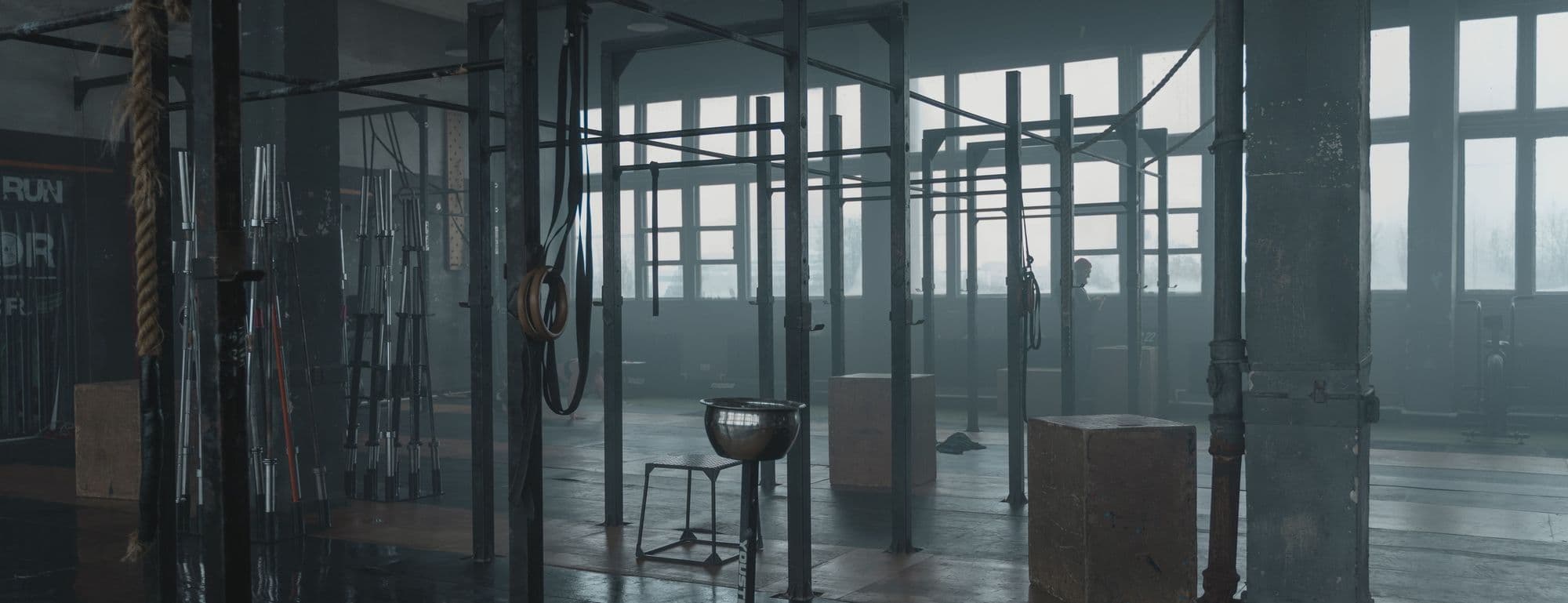 Interieur d'une salle de fitness fonctionnel, materiel en place, lumiere rasante