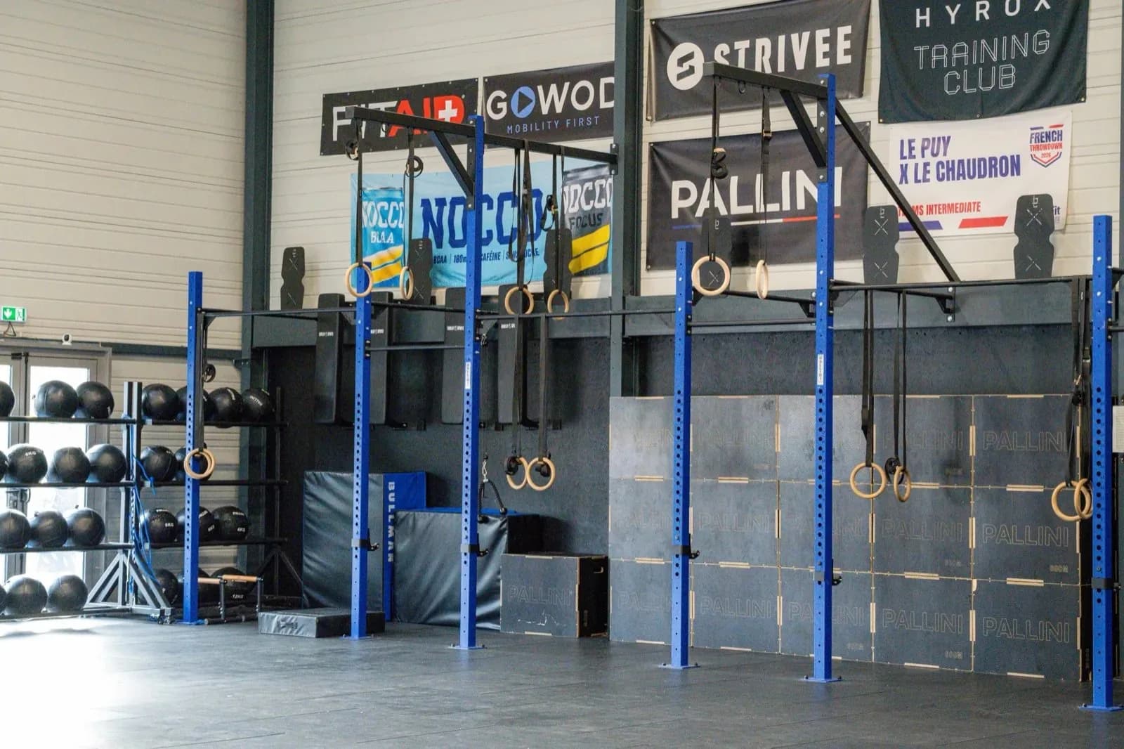 Espace principal de CrossFit Le Puy, rig bleu et banderole Hyrox Training Club