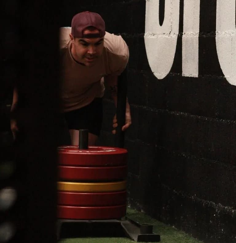 Athlète en sled push devant le lettrage mural de CrossFit les Remparts, Provins