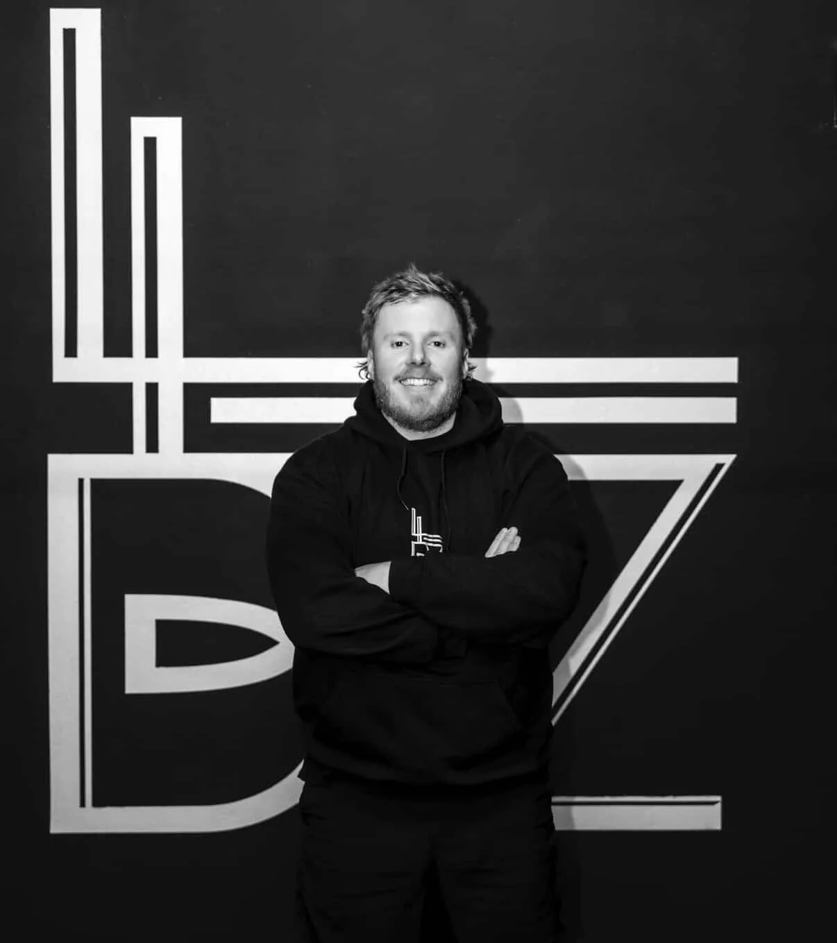 Coach du Local Biarritz devant le mur de marque LB de la salle